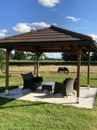 Garden furniture under the gazebo in the park of the gîte Le Benouchon