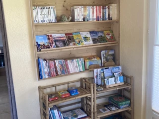 Bookcase in the gîte Le Benouchon with books, brochures and games